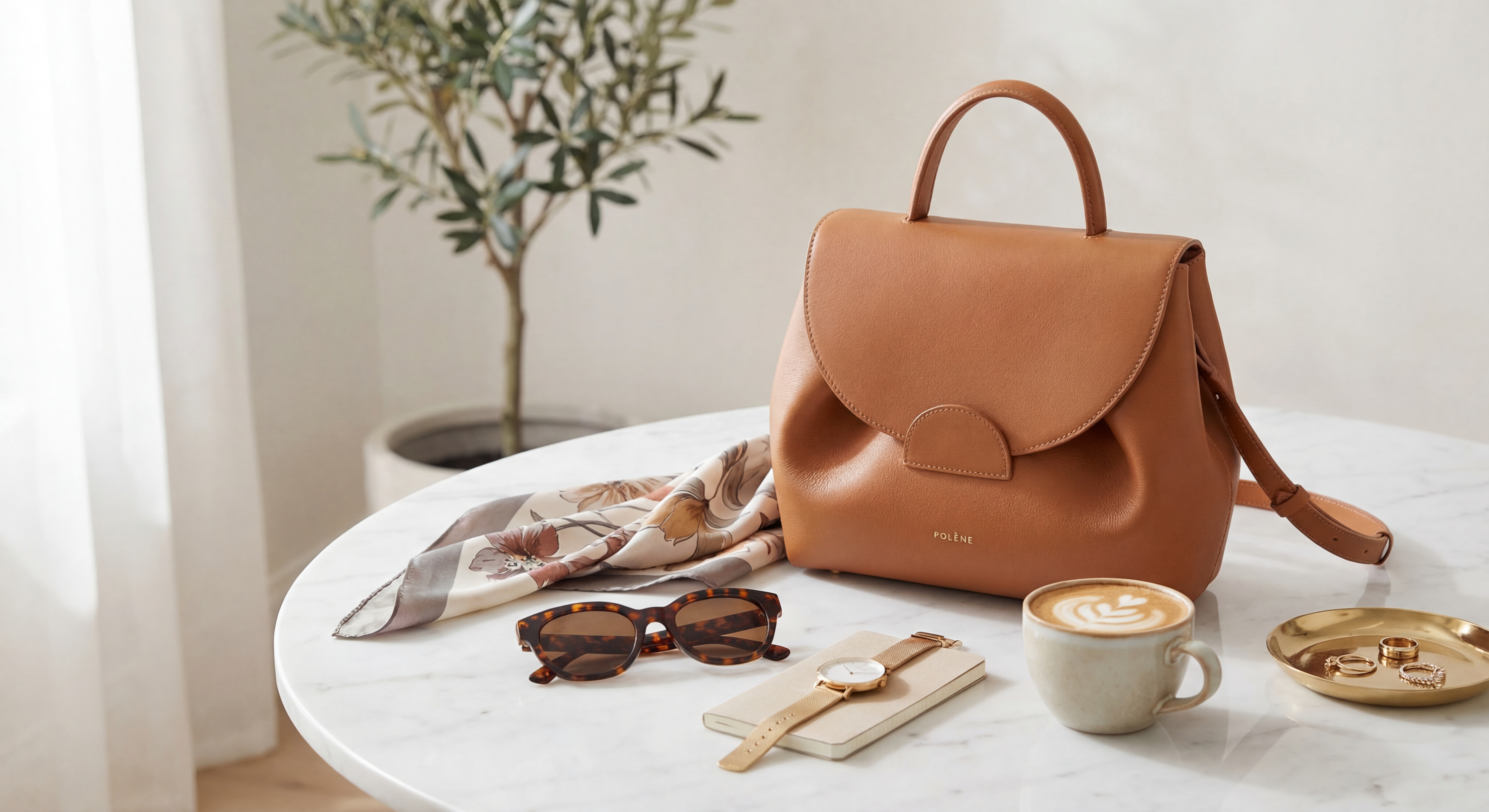 Sac en cuir Polène disposé élégamment sur une table en marbre avec accessoires de mode féminins