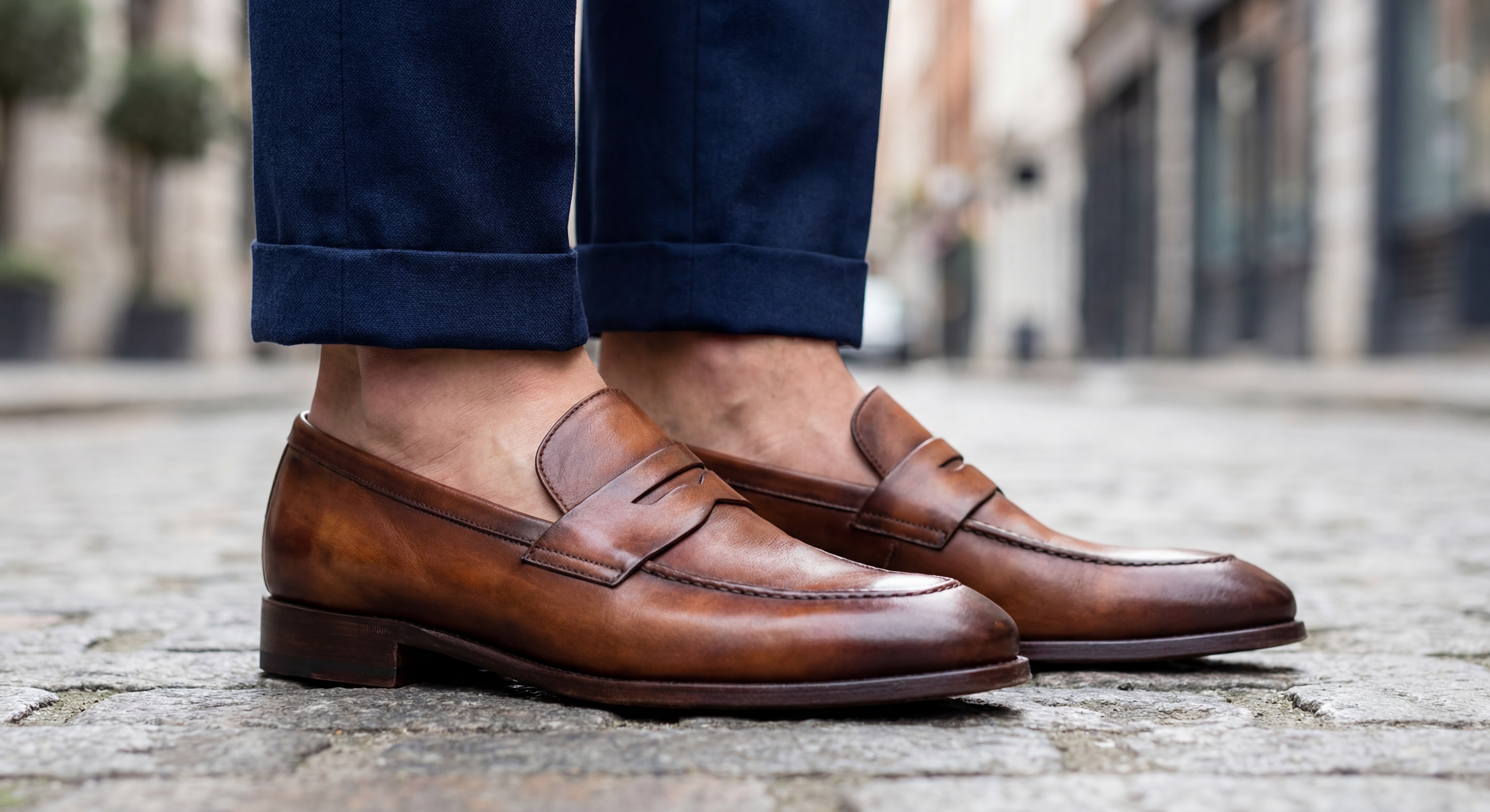 Gros plan sur des mocassins italiens en cuir marron portés avec pantalon court montrant la cheville