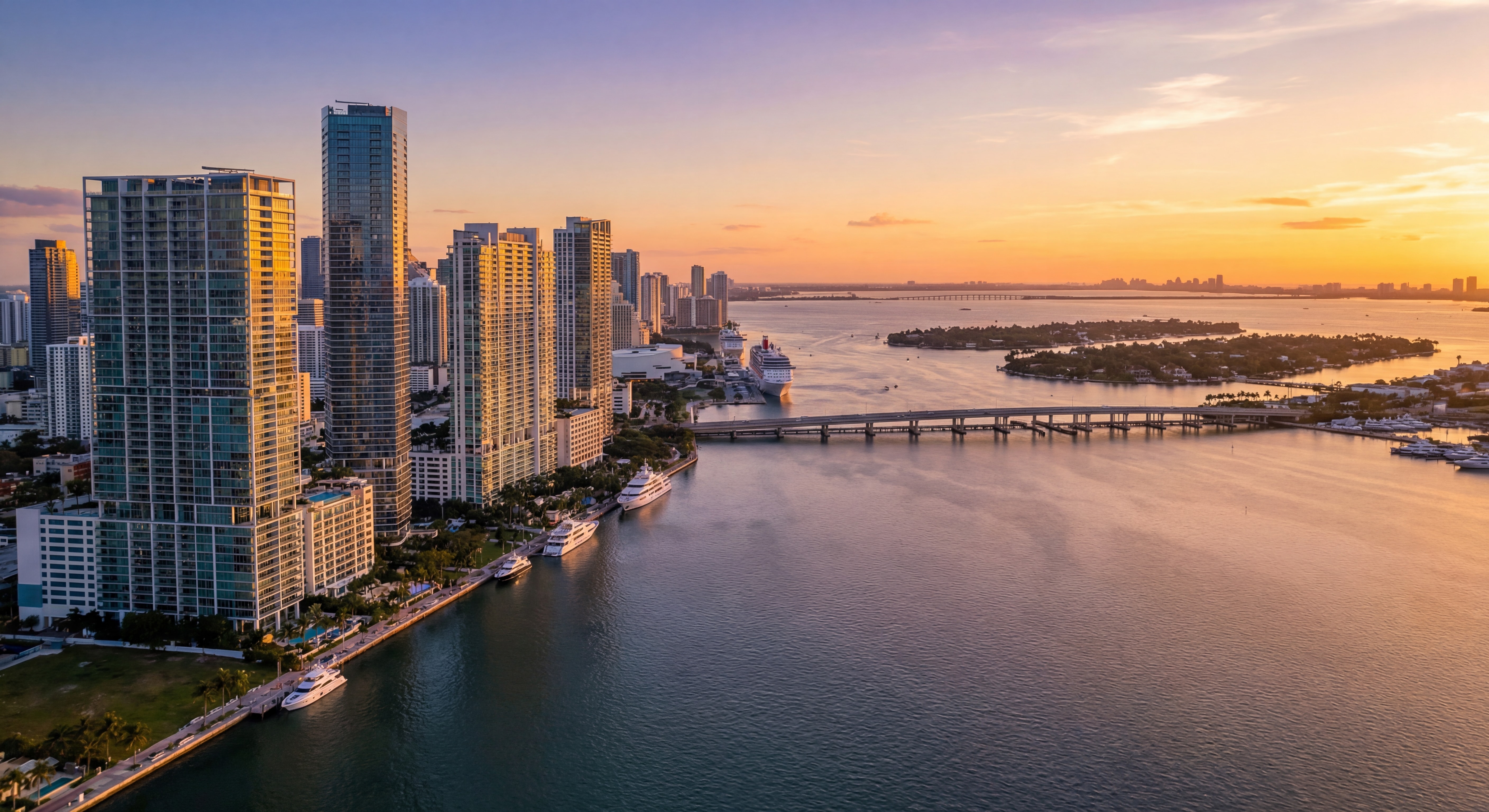 Aerial drone view of Miami's luxury skyline at sunset with Brickell towers and Biscayne Bay waterfront