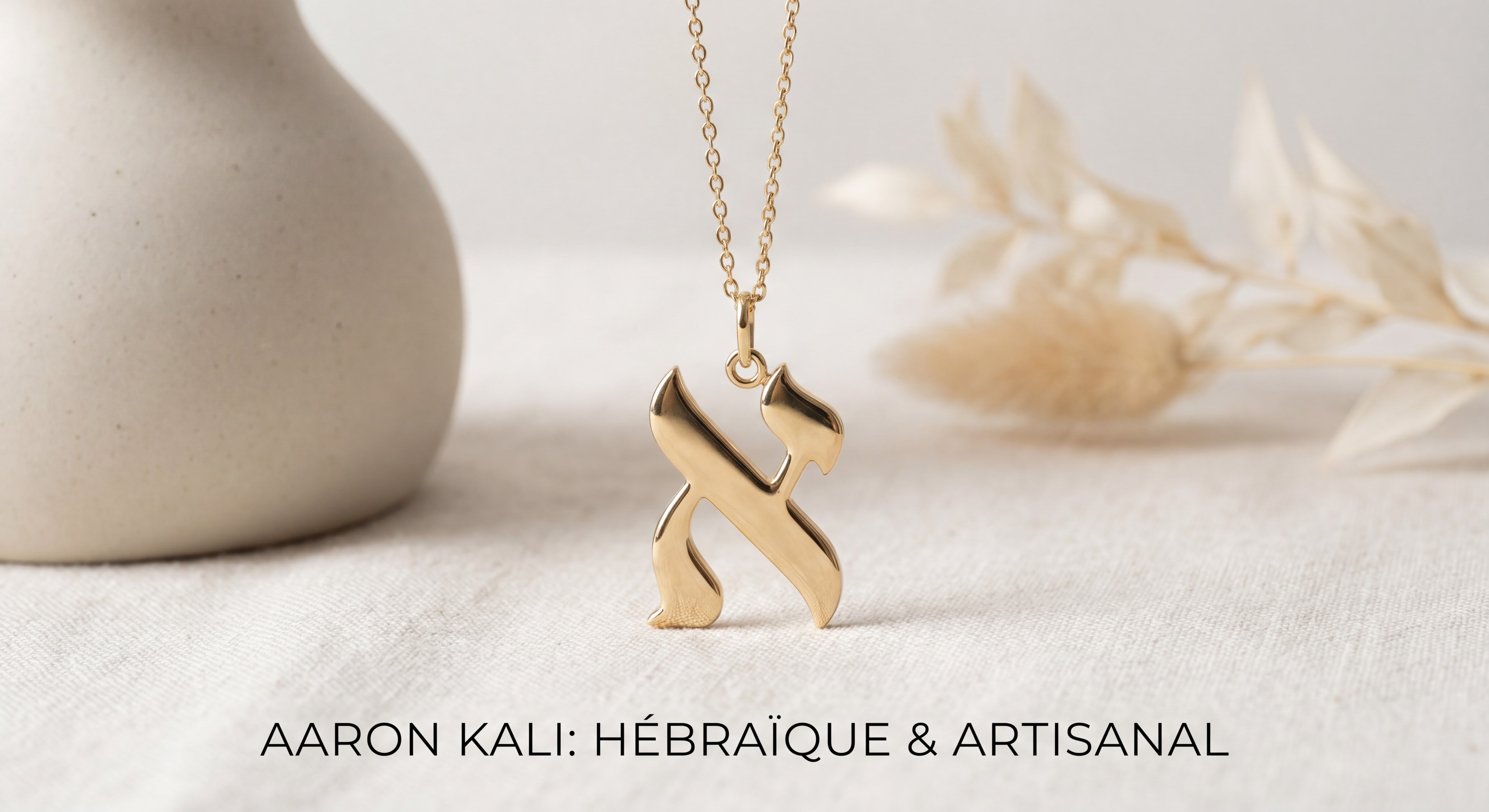 Pendentif lettre hébraïque en or 18k Aaron Kali sur fond épuré, bijou artisanal symbolique juif