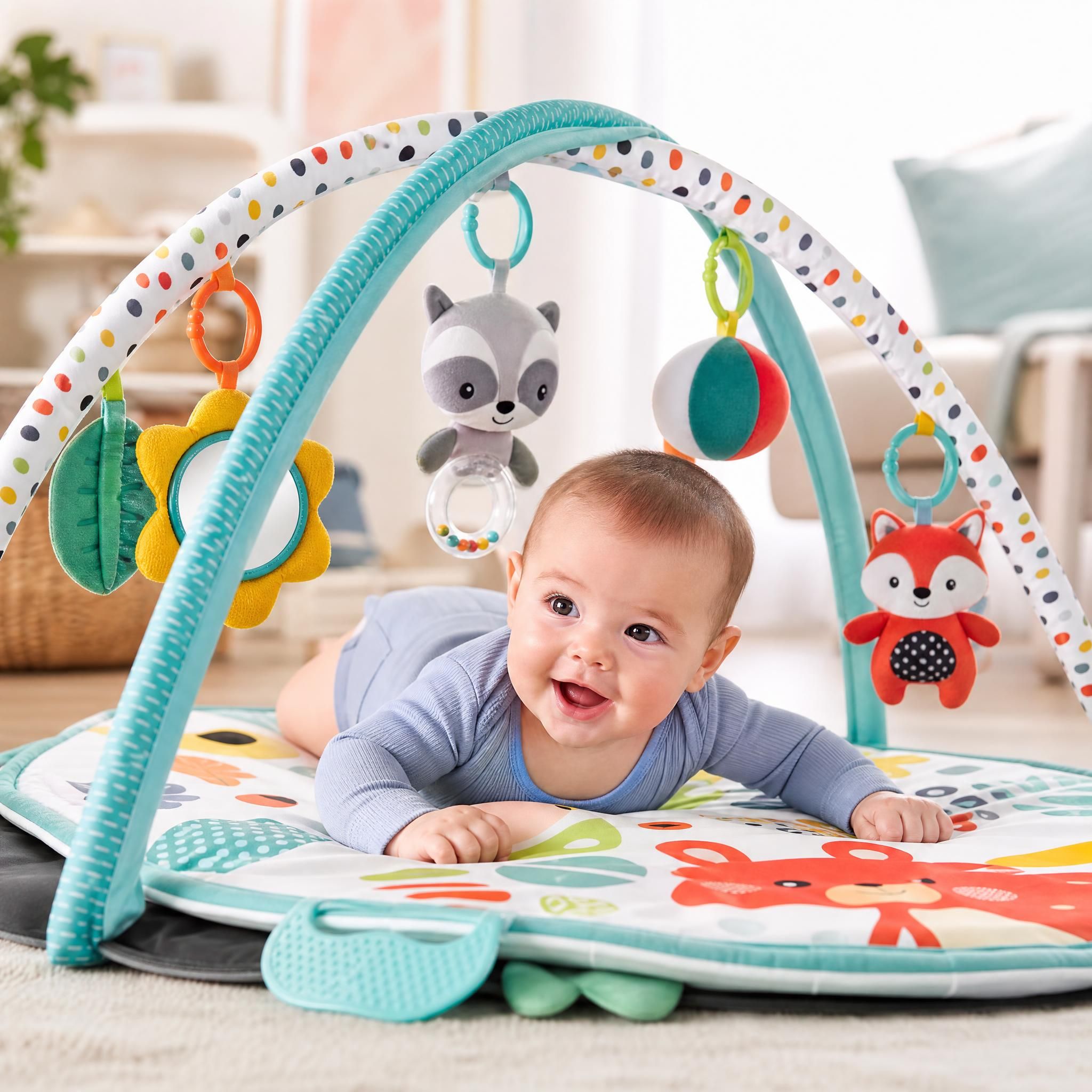 tapis d'éveil bébé coloré avec jouets sensoriels suspendus et bébé de 3 mois en position ventrale