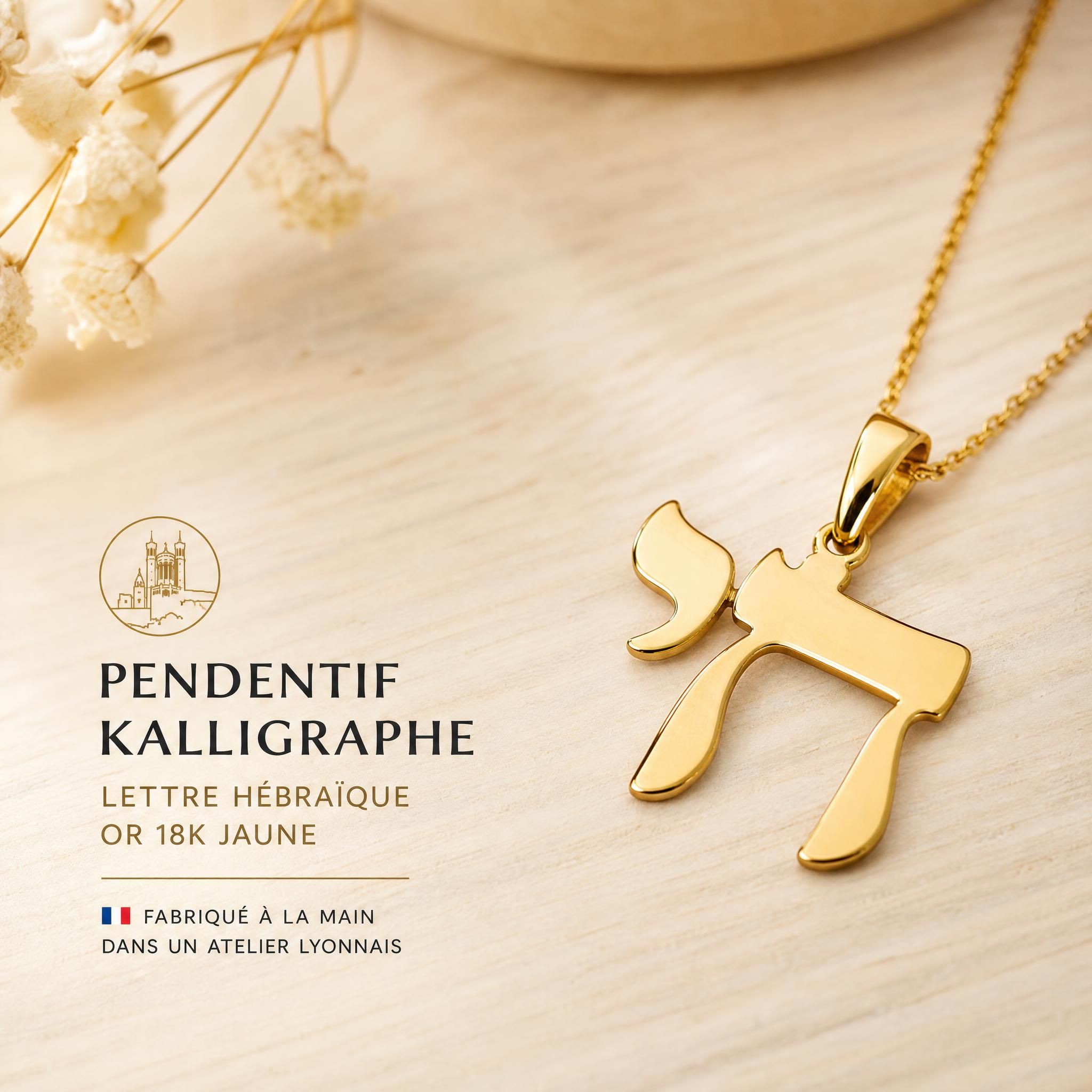 Pendentif Kalligraphe lettre hébraïque en or 18k jaune fabriqué à la main dans un atelier lyonnais, posé sur une surface en bois clair