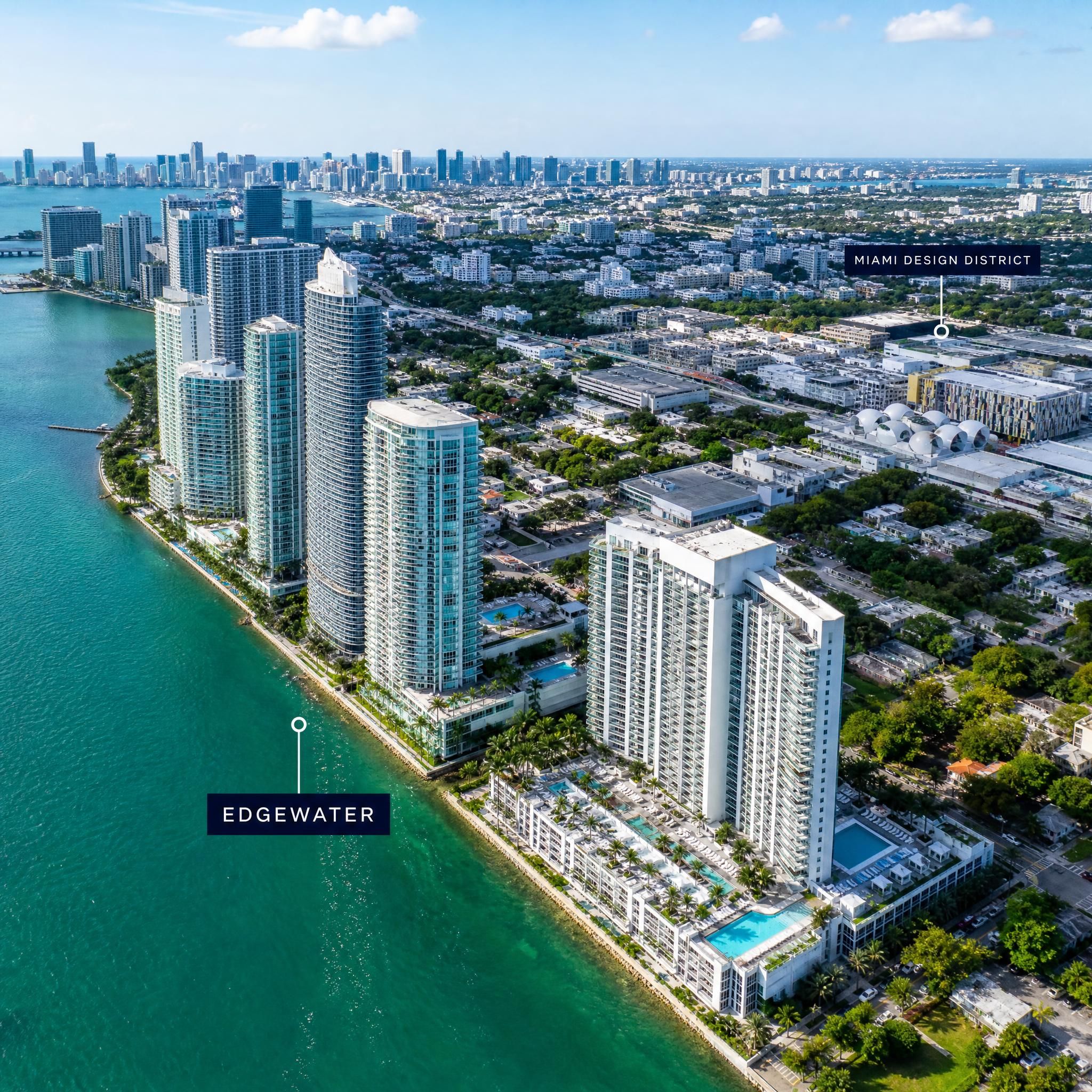 Aerial drone view of Miami's Edgewater neighborhood waterfront with luxury high-rise towers along Biscayne Bay and the Design District in the background