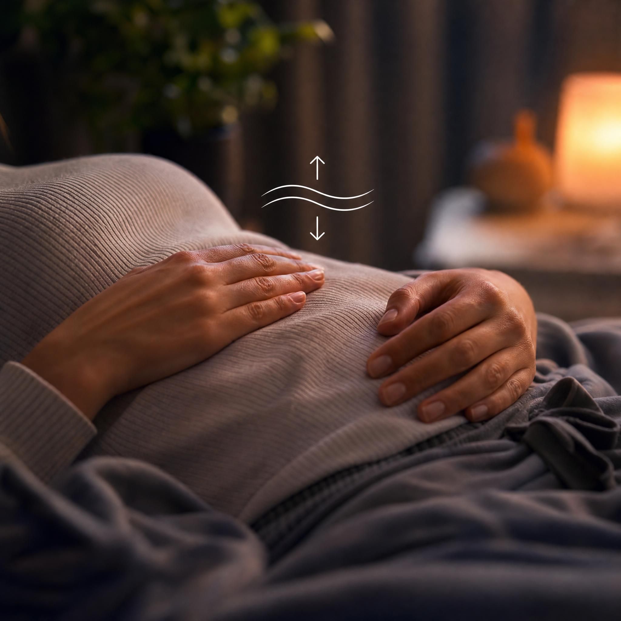 Gros plan sur des mains posées sur un ventre qui se soulève doucement au rythme de la respiration, ambiance tamisée et apaisante, symbolisant la pratique de l'auto-hypnose pour le sommeil