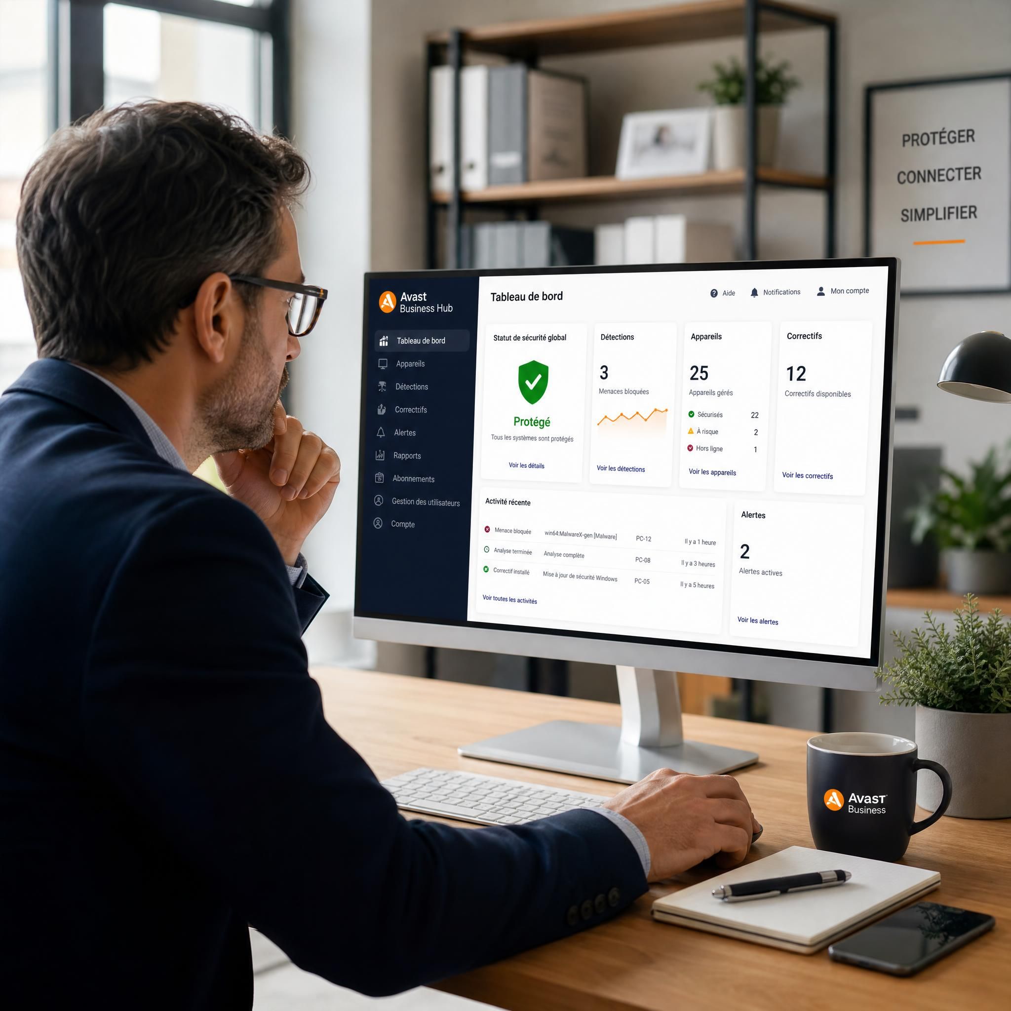 Chef d'entreprise PME devant son ordinateur avec tableau de bord de cybersécurité Avast Business Hub sur écran, bureau professionnel