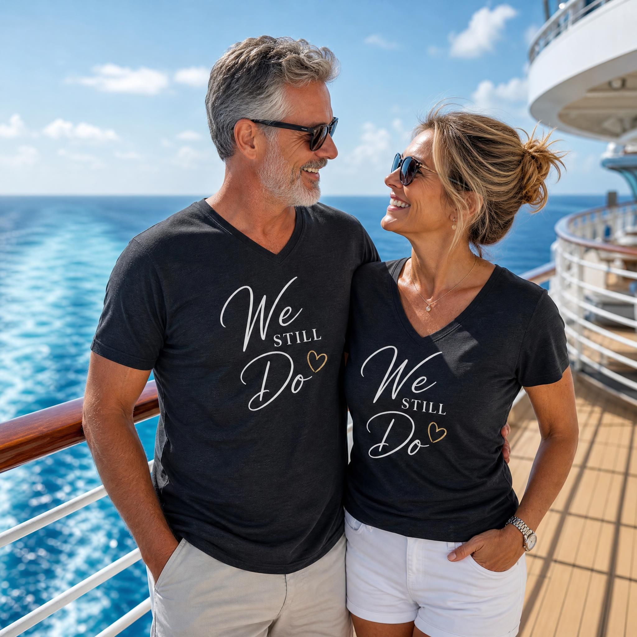Couple on a cruise deck wearing matching We Still Do anniversary V-neck shirts