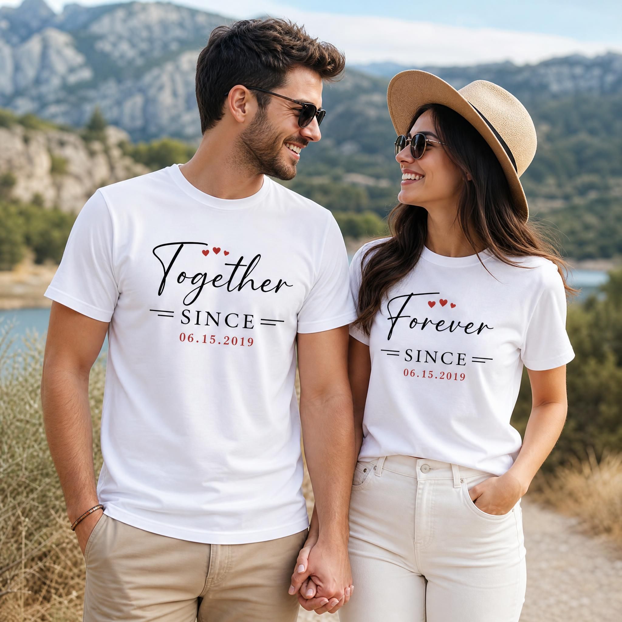 Couple wearing matching custom anniversary shirts outdoors during a photoshoot, smiling and holding hands