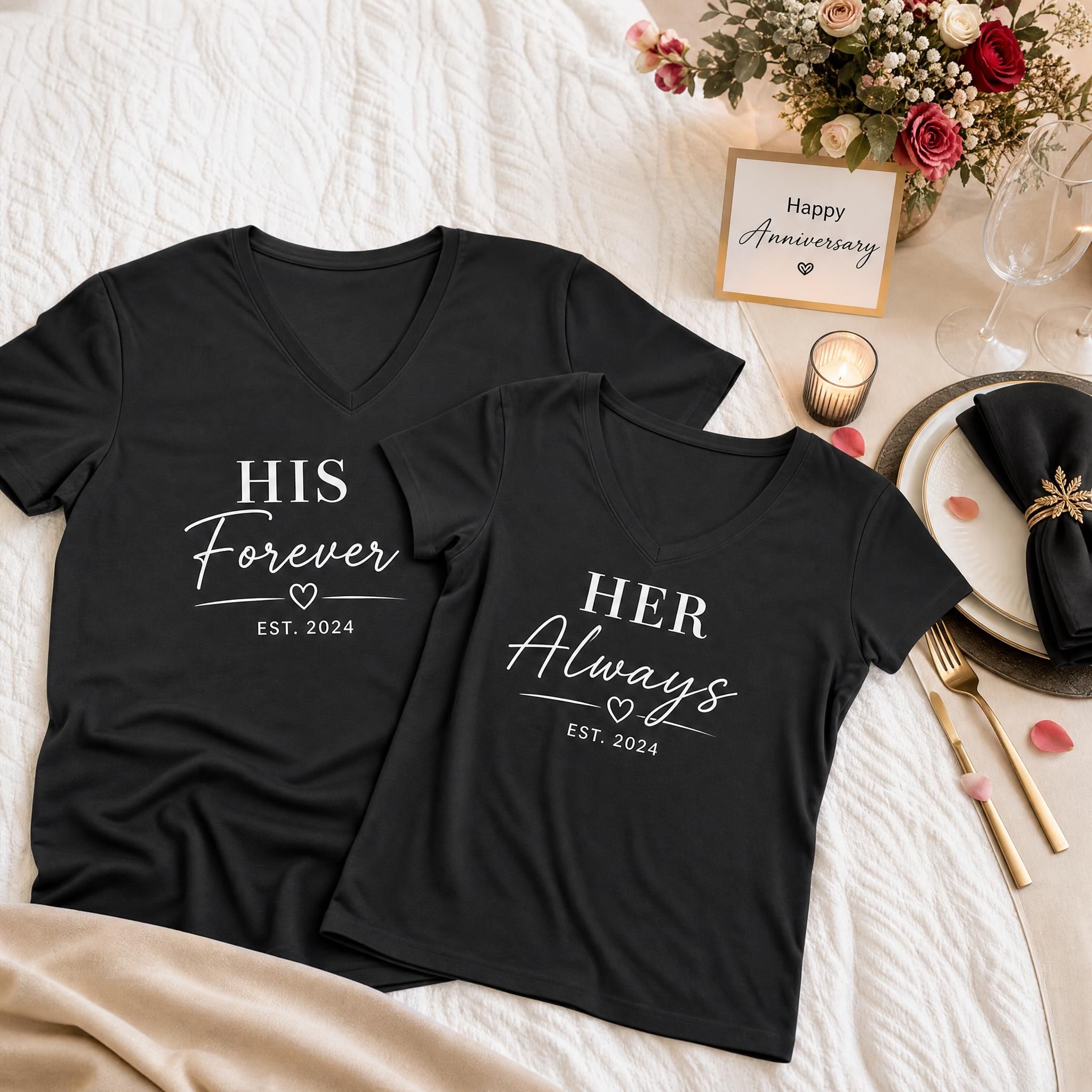 His and hers matching anniversary V-neck shirts laid flat on a bed next to anniversary dinner table decorations