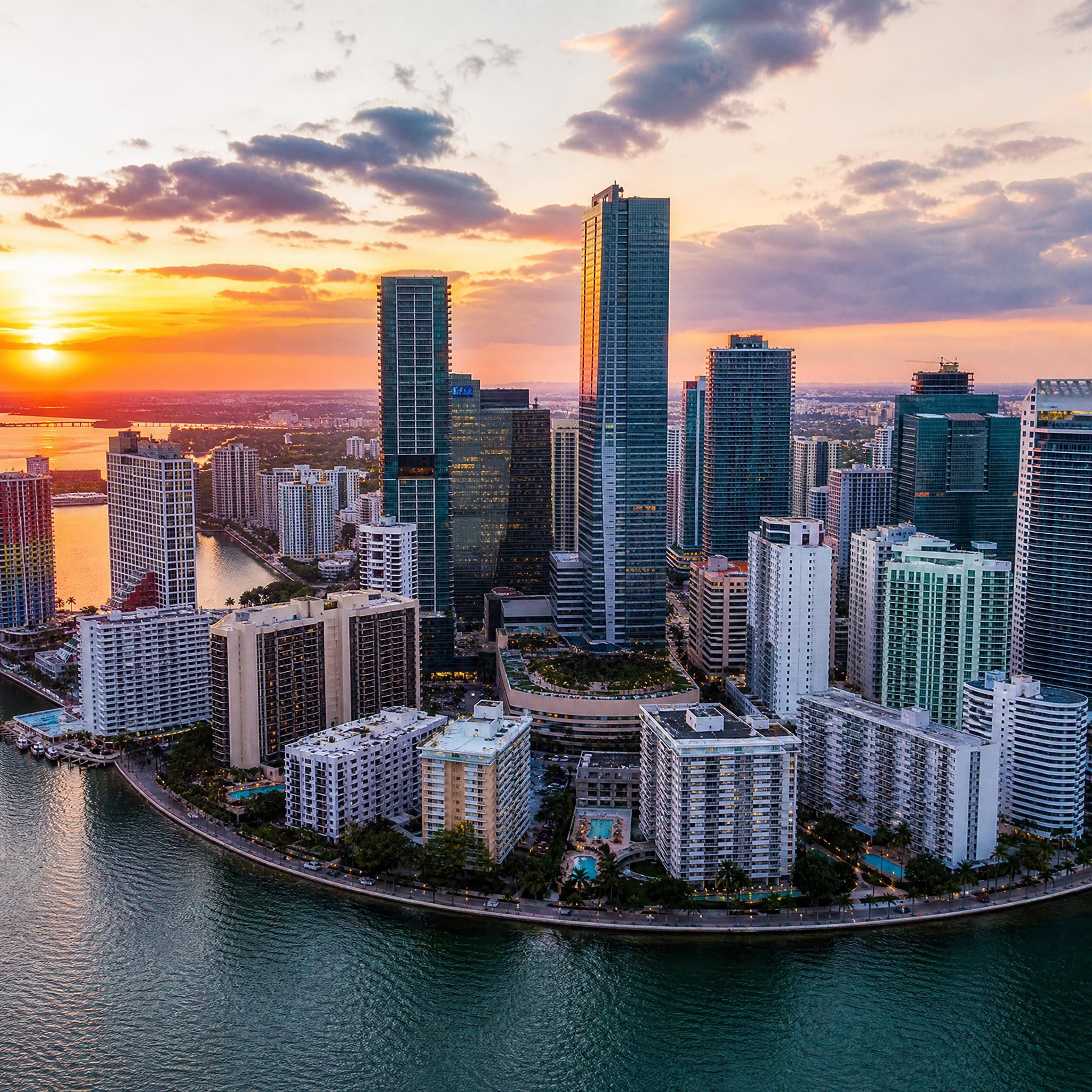 Aerial drone view of Miami's Brickell skyline at sunset with luxury high-rise towers and Biscayne Bay waterfront