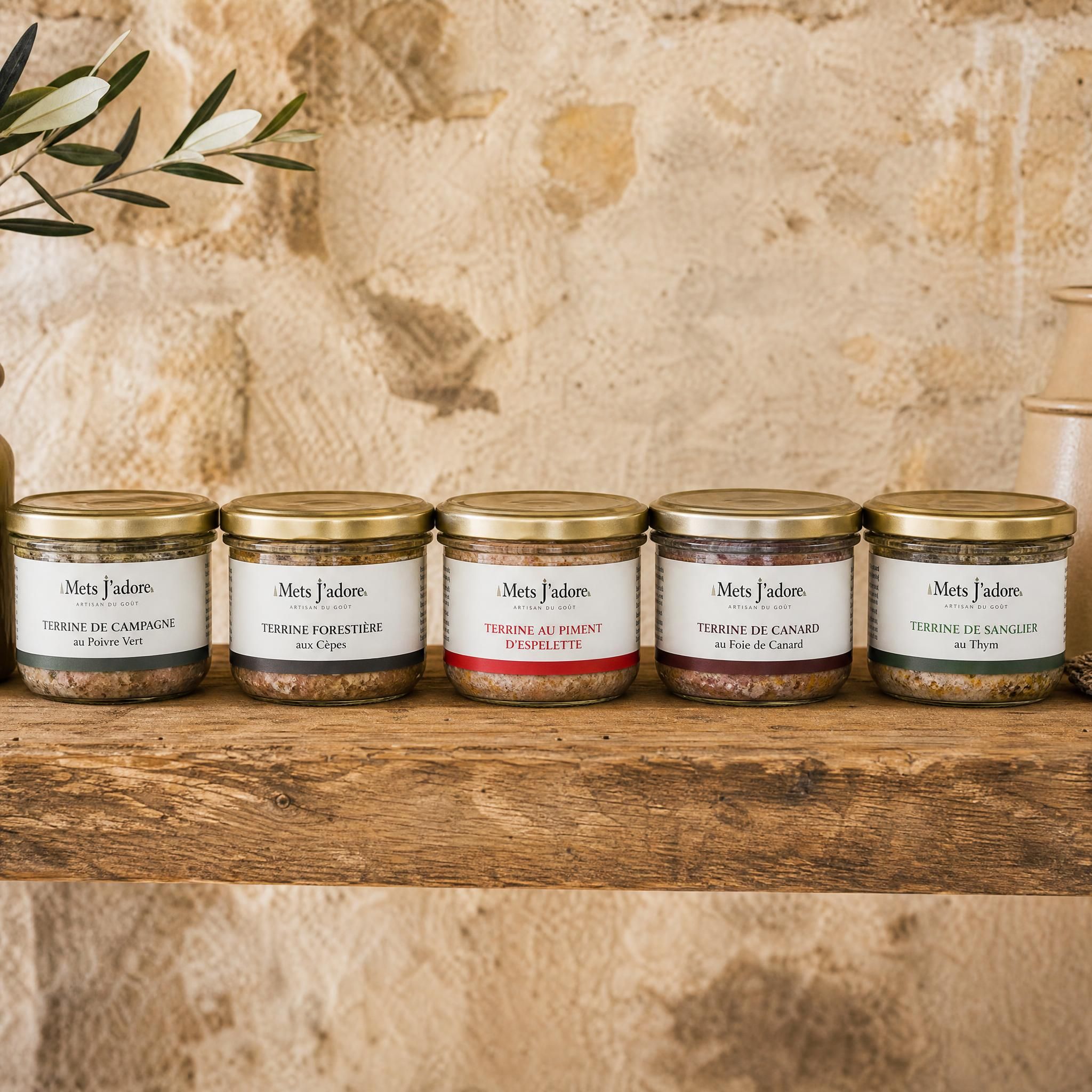 Bocaux de terrines artisanales Mets J'adore alignés sur une étagère en bois, fond rustique en pierre