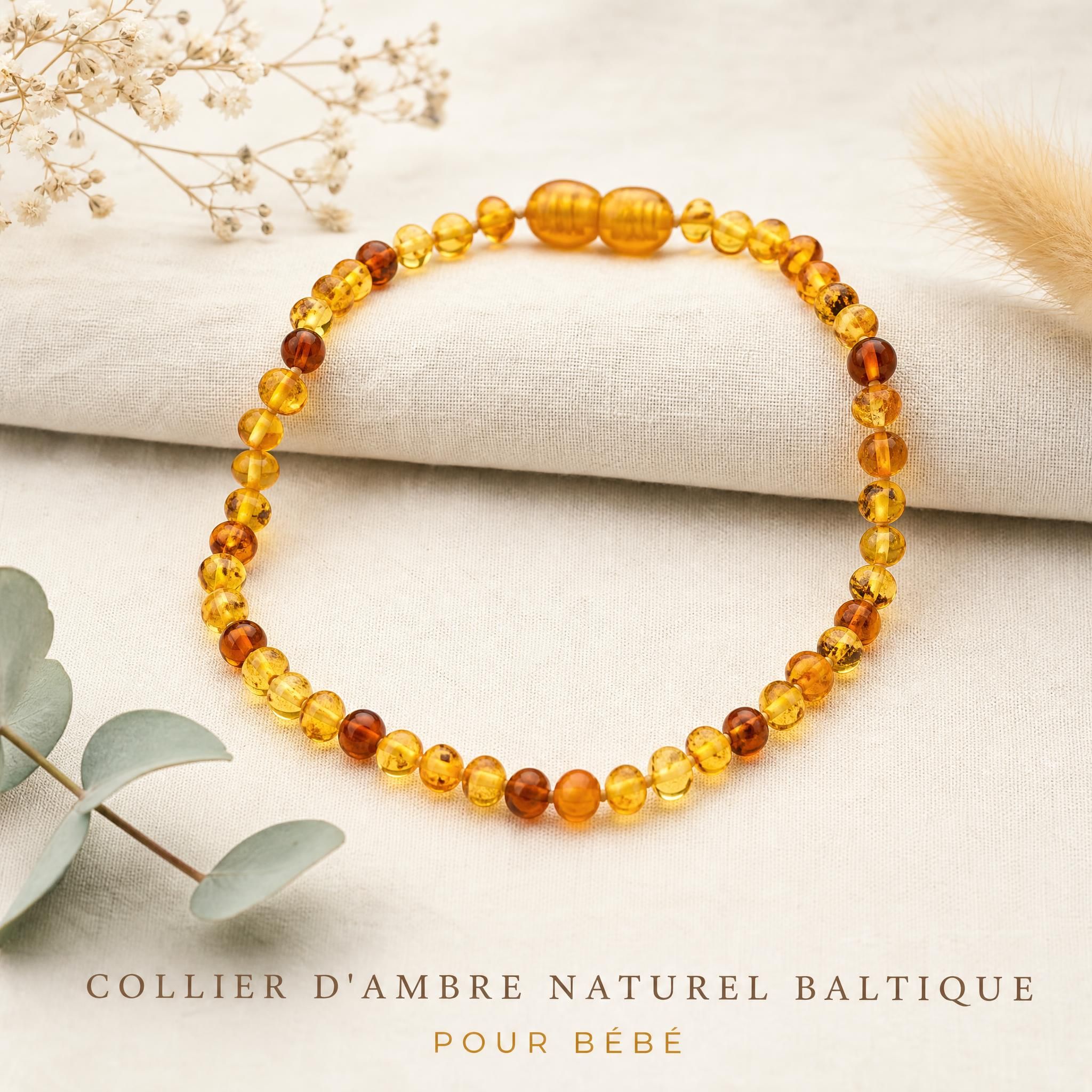 collier d'ambre naturel baltique pour bébé posé sur fond doux et naturel, perles dorées ambrées authentiques