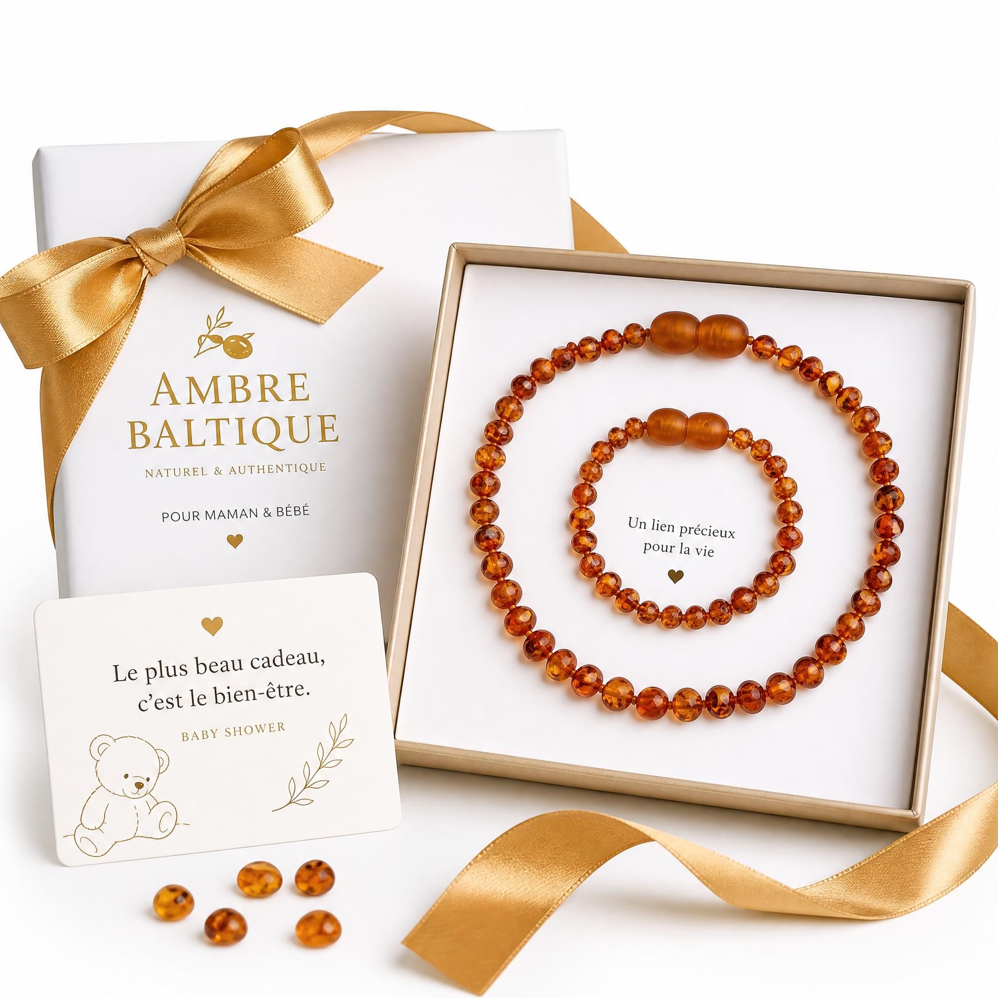 Pack cadeau ambre baltique maman et bébé, collier ambre naturel cognac sur fond blanc avec ruban doré, idée cadeau baby shower original
