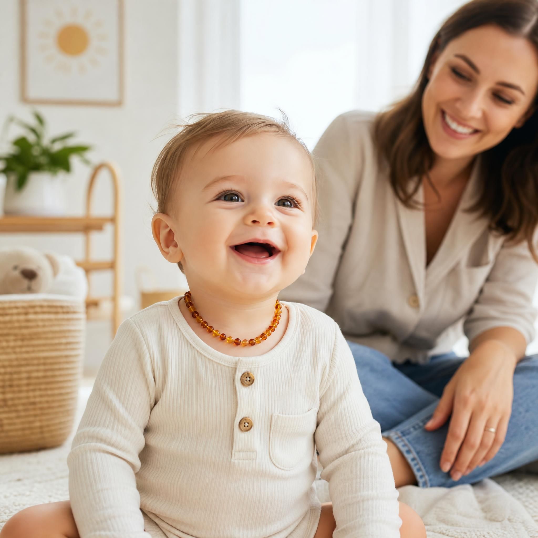 bébé souriant portant un collier ambre naturel baltique en journée sous la surveillance d'un parent